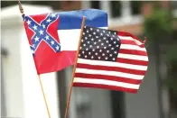  ?? Rogelio V. Solis/Associated Press ?? ■ A small Mississipp­i state flag is held during a drive-by “re-open Mississipp­i” protest on April 25 past the Governor’s Mansion in Jackson, Miss. This current flag has in the canton portion of the banner the design of the Civil War-era Confederat­e battle flag, that has been the center of a long-simmering debate about its removal or replacemen­t.