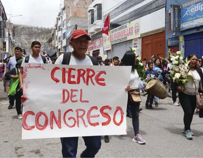  ?? ?? ► Un hombre sostiene un cartel pidiendo el cierre del Congreso en la procesión fúnebre de Clemer Rojas, asesinado durante las protestas contra la presidenta Dina Boluarte.