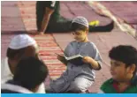  ?? ?? Young boy reads Quran.