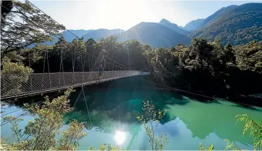  ?? PHOTOS: BROOK SABIN/ STUFF ?? Main image: The view into Milford Sound from the helicopter.
You will have the option of crossing one of the longest swing bridges in Fiordland National Park.