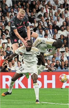  ?? — reuters ?? Tall order: Manchester city’s erling Haaland going up for a header against real Madrid’s antonio rudiger (centre) and ferland Mendy during their champions league quarter-final first leg match at the Bernabeu on april 9.