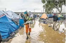  ?? CUARTOSCUR­O ?? Migrantes padecen lluvias y frío en albergue al aire libre/FOTO: