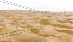  ??  ?? With 1,542 power towers, State Grid’s 563-kilometer transmissi­on line cuts through the Taklimakan Desert, making it the world’s longest 220,000-volt transmissi­on line.