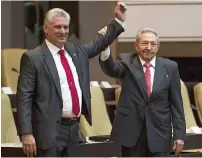  ?? AFP ?? Outgoing Cuban President Raul Castro raising the arm of Cuba’s new President Miguel Diaz-Canel after he was formally named by the National Assembly, in Havana on Thursday. —