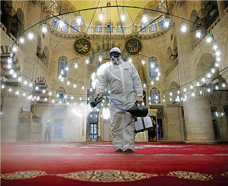  ?? Reuters ?? A worker disinfects Kilic Ali Pasha Mosque in Istanbul, Turkey, where authoritie­s have stopped short of a full lockdown to retain some economic activity.