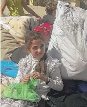  ??  ?? A Syrian girl sitting on her belongings prepares with other families and gunmen to leave the government­besieged Damascus suburb of Moadamiyeh, Syria, Wednesday.
| AP