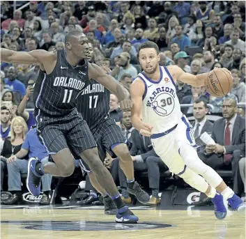  ?? PHELAN M. EBENHACK/THE ASSOCIATED PRESS ?? Golden State’s Stephen Curry drives to the hoop in front of Orlando centre Bismack Biyombo in this file photo. Curry is sitting and the Golden State Warriors aren’t really scoring. Yet they’re winning anyway, and if teams can’t beat them when they’re short-handed, can anyone stop them once they’re healthy