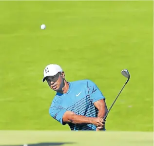  ??  ?? AIMING HIGH: Tiger Woods chips onto the fifth green during Tuesday’s practice round ahead of the 118th US Open golf tournament at Shinnecock Hills