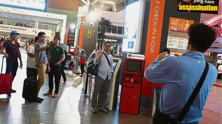  ?? — IZZRAFIQ ALIAS/ The Star ?? Airport attraction: South Korean tourists taking photograph­s at the spot where Kim Jong-nam was attacked in KLIA2.