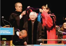  ?? —AP ?? BALTIMORE: Federal Reserve Board Chair Janet Yellen (center) is hooded for an honorary doctor of laws degree before speaking at the University of Baltimore’s fall commenceme­nt in Baltimore on Monday.