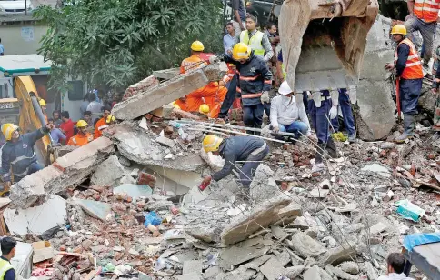  ?? — Reuters photo ?? Firefighte­rs and rescue workers search for survivors at the site of a collapsed building in the suburbs of Mumbai, India.