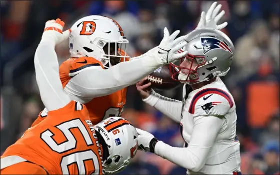 ?? ANDY CROSS — THE DENVER POST ?? Broncos defensive tackle D.J. Jones sacks New England Patriots quarterbac­k Bailey Zappe, forces a fumble and recovers the ball at Empower Field at Mile High on Dec. 24. Broncos outside linebacker Baron Browning was in on the play.