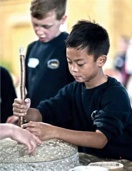  ??  ?? Above: Adam Grieve oversees the livestock auction. Right: Sean Magtuloy from Newtown Primary School in St Boswells gets to grips with mill stones.