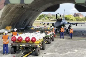  ?? AP file photo ?? Military personnel stand next to U.S. Harpoon A-84, anti-ship missiles and AIM-120 and AIM-9 air-to-air missiles prepared for a weapon loading drills in front of a U.S. F-16V fighter jet at the Hualien Airbase in Taiwan’s southeaste­rn Hualien county, Aug. 17. The intense firefight over Ukraine has the Pentagon rethinking its weapons stockpiles. If another major war broke out today, would the U.S. have enough ammunition to fight? It’s a question Pentagon planners are grappling with not only as the look to supply Ukraine for a war that could stretch for years, but also as they look to a potential conflict with China.