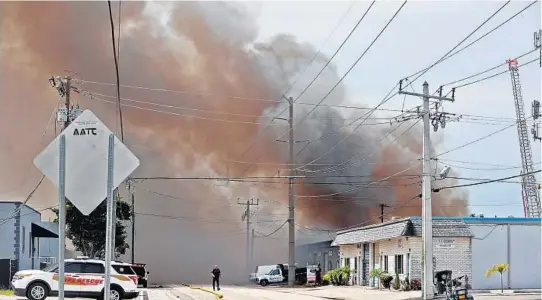  ?? PHOTOS BY AMY BETH BENNETT/SOUTH FLORIDA SUN SENTINEL ?? A fire is shown in progress Wednesday at Barco Sales & Manufactur­ing in the Oakland Park warehouse district. Explosions, smoke and flames consumed the warehouse, forced evacuation­s, and cut power in Oakland Park, fire officials said.