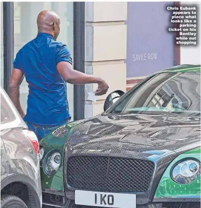  ??  ?? Chris Eubank appears to place what looks like a parking ticket on his Bentley while out shopping