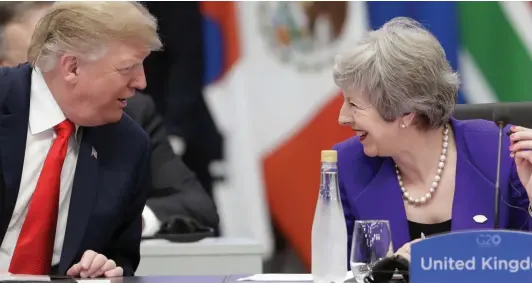  ??  ?? Nice to see you: Donald Trump and Theresa May exchange pleasantri­es around the G20 table