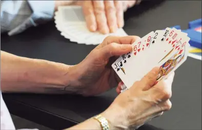  ?? Hearst Connecticu­t Media file photo ?? A player looks over a hand as the Perfectly Polite Bridge Group meets at the YMCA in Greenwich in June 2018.