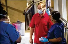  ??  ?? CVS employee Jim Crispyn gets his temperatur­e checked Monday during check-in in preparatio­n for the opening of the COVID-19 drive-through testing center in Atlanta.