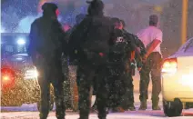  ?? JUSTIN EDMONDS/GETTY IMAGES ?? A shooting suspect is led away in handcuffs by police after a standoff at a Planned Parenthood clinic in Colorado Springs, Colorado.