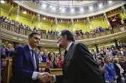  ?? MARCOU / GETTY IMAGES PIERRE-PHILIPPE ?? New Prime Minister Pedro Sanchez (left) shakes hands with former Prime Minister Mariano Rajoy after Sanchez won the no-confidence motion at the lower house of the Spanish Parliament on Friday in Madrid.