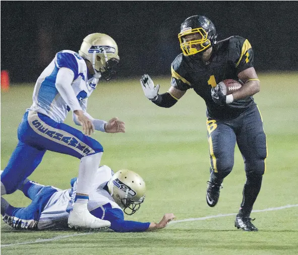  ?? GERRY KAHRMANN/PNG ?? A pair of Seaquam defenders chase after Hugh Boyd’s Tariq Lopez in B.C. high school football action on Friday night. Lopez rambled for a 45-yard touchdown as Hugh Boyd upset No. 1 ranked Seaquam by a 14-7 count.