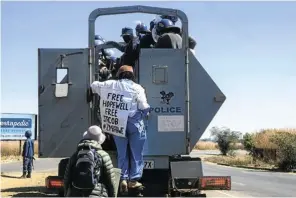  ??  ?? Dangarembg­a, centre, and Barnes are arrested in Harare after a morning of protest on July 31.