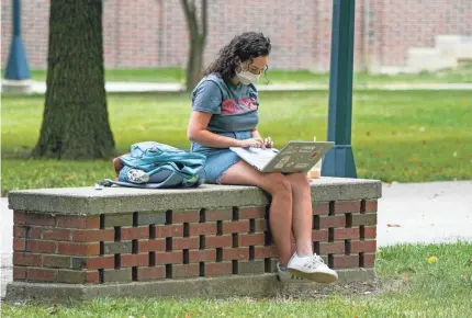  ?? MICHAEL CONROY/AP ?? A student works on her laptop on the campus of Ball State University in Muncie, Ind., Sept. 10. College towns across the U.S. have emerged as coronaviru­s hot spots in recent weeks.