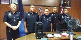  ??  ?? Zulkipli (centre) and his senior officers pose with some of the items recovered during the operation.