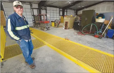  ?? NWA Democrat-Gazette/FLIP PUTTHOFF ?? Marty McConnell, fleet manager at Benton County’s Road Department, stands at a truck service area in one of three truck bays added at the department. Employees moved into the new bays about 10 days ago.