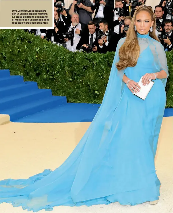  ??  ?? Diva. Jennifer López deslumbró con un vestido-capa de Valentino. La diosa del Bronx acompañó el modelo con un peinado semirecogi­do y aros con brillantes.