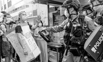  ?? ANTHONY KWAN/GETTY ?? A man wearing a “Voting Is A Right” costume and police exchange words during a protest Sunday in Hong Kong. Police arrested 289 people opposed to the government's decision to postpone elections for Hong Kong's legislatur­e. The elections were to have taken place Sunday, but were postponed for a year due to COVID-19 and a new national security law.