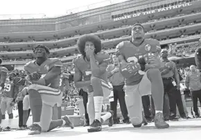  ?? ASSOCIATED PRESS ?? Colin Kaepernick, center, was vilified when he took a knee in 2016 during the national anthem to protest police brutality and racial injustice.