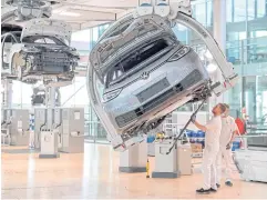  ?? REUTERS ?? Technician­s work in the assembly line of German carmaker Volkswagen’s electric ID 3 car in Dresden, Germany on June 8, 2021.