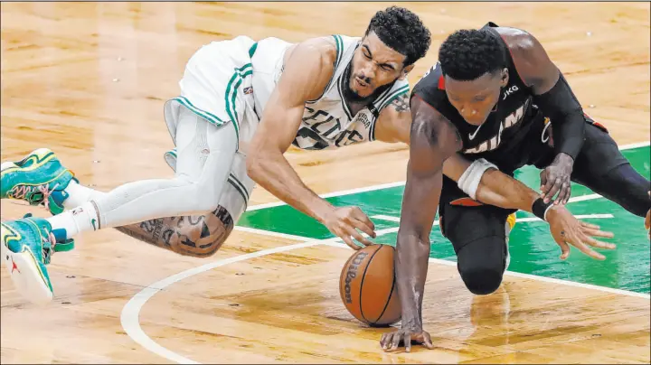  ?? Michael Dwyer The Associated Press ?? Boston’s Jayson Tatum and Miami’s Victor Oladipo battle for the ball during Game 3. Tatum is among the many players nursing injuries, having suffered a stinger during the Saturday afternoon loss.