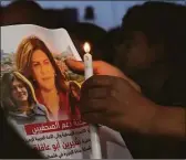  ?? Associated Press ?? A mourner holds a picture of slain journalist Shireen Abu Akleh.