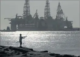  ?? ERIC GAY — THE ASSOCIATED PRESS FILE ?? A man fishes near docked oil drilling platforms in Port Aransas, Texas.