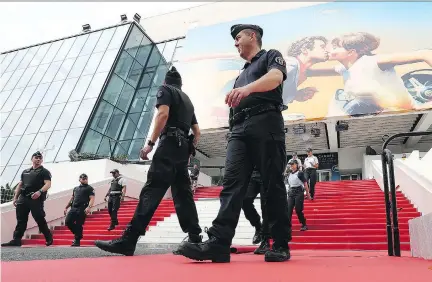  ?? GETTY IMAGES ?? Police and officials patrol the red carpet at the Cannes Palais des Festivals on the eve of the 71st edition of the famed event’s opening.