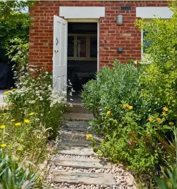  ??  ?? Above and above right:
The back garden is a generous size, thanks to the home’s corner plot; its proportion­s are accentuate­d by Keely’s dramatic, sculptural planting schemes
Right: The stained-glass door and sidelights were replaced with Keely’s bespoke design and produced by Tim
Gill Glass. The hallway has been widened by removing a chimney breast and a local vintage tile specialist, Max Tansley, added handpainte­d floor tiles to match the existing geometric design. Reproducti­on versions can be found at London Mosaic. The pink paint in the hallway above the dado rail is Plaster IV and below it is Perse Grey, both from Paint & Paper Library