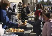  ?? ?? Volunteers are giving out Bannocks to Students for refreshmen­t at Prince Arthur Community School.