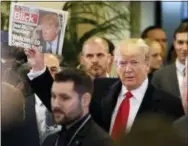  ?? THE ASSOCIATED PRESS ?? President Donald Trump holds up Swiss newspaper ‘Blick’ as he arrives Friday at the Congress Center on the last day of the annual meeting of the World Economic Forum, WEF, in Davos, Switzerlan­d.