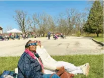  ?? HANK SANDERS/DAILY SOUTHTOWN ?? Deborah Bennett, left, views the solar eclipse Monday with Aina Holmes at Pulaski Woods Forest Preserve in Willow Springs.