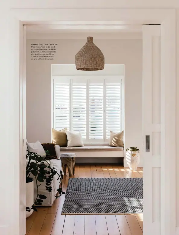  ??  ?? LIVING Cavity sliders allow the front living room to be used as a guest bedroom and kids' playroom. Among the pieces pictured here are cushions, a Teak Tooth side table and an urn, all from Ornament.