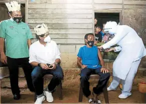  ?? — Bernama ?? Towards the target: Khairy (second from left) and Jempol MP datuk Mohd salim shariff looking on as a man gets inoculated at a mobile vaccinatio­n centre in Kampung Baru Peti, Jempol.