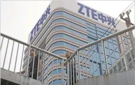  ?? ASSOCIATED PRESS FILE PHOTO ?? Pedestrian­s pass a ZTE building earlier this month in Beijing. The Chinese telecommun­ications giant was saved by a deal with the U.S., but some in Congress worry the country is being too lenient on a violator of sanctions.