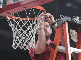  ?? (NWA Democrat-Gazette/J.T. Wampler) ?? Fixing a net is just one of the things that video coordinato­r Riley Hall does to help the Arkansas men’s basketball team that goes beyond his job descriptio­n.