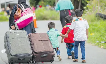  ?? GEOFF ROBINS/AFP/GETTY IMAGES ?? Asylum seekers make their way toward the Canada/U.S. border near Champlain, N.Y. earlier this month. From July 1 to Aug. 10, 4,750 refugee claims were made in Quebec, compared to 6,580 claims from January to June.