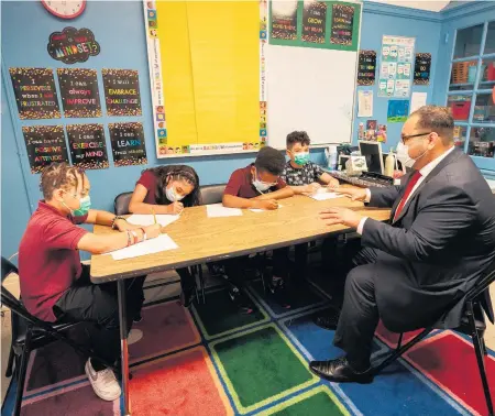  ?? JESSICA GRIFFIN TNS ?? Left to right, Devyn Smith, Cindy Hernandez, Jayden Hughes and Ronald Perez work with assistant principal Julio Nuñez.