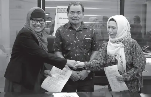  ??  ?? TECHNICAL Education Executive Director Ruby Andong (left most) and Hadji Buto School of Arts and Trade Vocational Superinten­dent Vethlana Abdurajak seal the partnershi­p with a handshake following the signing of memorandum of agreement for the establishm­ent of provisiona­l TVET training center in Sulu during a meeting in Cotabato City. Also in the photo is Minister Mohagher Iqbal.