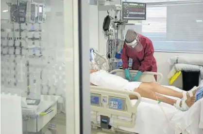 ?? Foto: Unai Beroiz ?? Una enfermera atiende a un paciente ingresado en un box de la UCI del CHN.